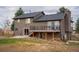 Backyard view of the house featuring a spacious deck with metal railings and a dark roof at 2312 Arabian Trl, Elizabeth, CO 80107