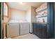 Bright laundry room featuring a washer, dryer, and cabinetry at 2312 Arabian Trl, Elizabeth, CO 80107