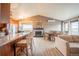 Open-concept living room with hardwood floors, fireplace, dining area and great natural light at 2312 Arabian Trl, Elizabeth, CO 80107