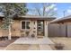 Charming single-story home features a brick facade, modern front door, and cozy outdoor seating area at 2810 N Harrison St, Denver, CO 80205