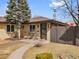 Beautifully landscaped front yard of this single-story brick home features a cozy seating area and modern front door at 2810 N Harrison St, Denver, CO 80205