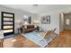 Bright living room features hardwood floors, a stylish sofa, and ample natural light from a large window at 2810 N Harrison St, Denver, CO 80205