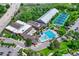Aerial view of a community center with a pool, tennis courts, and various recreational facilities surrounded by greenery at 302 Northridge Rd, Highlands Ranch, CO 80126