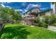 An elevated wood deck overlooks the lush lawn and mature trees of the backyard at 302 Northridge Rd, Highlands Ranch, CO 80126