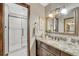 Modern bathroom featuring a vanity with granite counters and framed mirror, with a glass enclosed shower at 302 Northridge Rd, Highlands Ranch, CO 80126