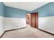 Small bedroom features blue accent wall, neutral carpet and closet at 302 Northridge Rd, Highlands Ranch, CO 80126