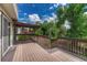 A home's wood deck includes a pergola and overlooks the back yard's mature shade trees at 302 Northridge Rd, Highlands Ranch, CO 80126