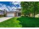 Traditional home exterior with a lush green lawn and mature shade tree, offering curb appeal at 302 Northridge Rd, Highlands Ranch, CO 80126