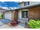Inviting front entrance with brick accents, complemented by landscaping and a convenient two-car garage at 302 Northridge Rd, Highlands Ranch, CO 80126