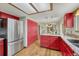 Kitchen area featuring stainless refrigerator, granite counters, and red cabinets at 302 Northridge Rd, Highlands Ranch, CO 80126