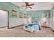 Large bedroom features bright windows, neutral carpet and light blue accent wall at 302 Northridge Rd, Highlands Ranch, CO 80126