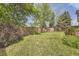 Exterior backyard with mature trees and landscaping featuring a lawn and fenced perimeter at 9001 W Chatfield Dr, Littleton, CO 80128