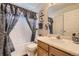 Bathroom features white tile, vanity with sink, and decorative blue accents, complemented by a stylish shower curtain at 9001 W Chatfield Dr, Littleton, CO 80128