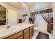 Bright bathroom features a double sink vanity with a large mirror and a shower-tub combo at 9001 W Chatfield Dr, Littleton, CO 80128