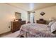 Bedroom featuring carpet flooring, a patterned quilt on the bed, and a vintage wooden dresser at 9001 W Chatfield Dr, Littleton, CO 80128