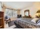 Bright bedroom features neutral walls, a striped comforter and a wood dresser with a decorative mirror at 9001 W Chatfield Dr, Littleton, CO 80128