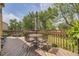 Spacious outdoor deck features mature trees, a weathered wood floor, and a metal table and chairs at 9001 W Chatfield Dr, Littleton, CO 80128