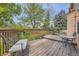 Exterior view of the spacious deck with multiple seating areas surrounded by mature trees and landscaping at 9001 W Chatfield Dr, Littleton, CO 80128