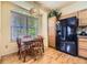 Bright dining area featuring wood floors, oak table set, and a modern hanging light fixture by a large window at 9001 W Chatfield Dr, Littleton, CO 80128