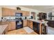 Bright kitchen featuring granite countertops, wooden cabinets, and stainless steel appliances, ideal for cooking enthusiasts at 9001 W Chatfield Dr, Littleton, CO 80128