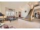 Inviting living room featuring a soaring ceiling, plush carpet, and a staircase leading to the upper level at 9001 W Chatfield Dr, Littleton, CO 80128
