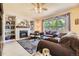 Comfortable living room with fireplace, built-in shelving, large window, plush sofas, and decorative accents at 9001 W Chatfield Dr, Littleton, CO 80128