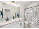 Cozy bathroom featuring a shower and a vanity sink with a large mirror and black hardware at 7889 Yampa River Ave, Littleton, CO 80125