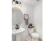 Clean half bathroom featuring a floating oval mirror and a vanity with a vessel sink at 7889 Yampa River Ave, Littleton, CO 80125
