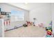 Bright playroom or bedroom with a window and space for lots of toys and playing on carpeted floor at 7889 Yampa River Ave, Littleton, CO 80125