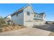 Rear exterior of a townhome with three garages and a convenient driveway, surrounded by landscaping at 7889 Yampa River Ave, Littleton, CO 80125