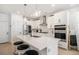 Stylish kitchen boasting white cabinetry, a center island with seating, and stainless steel appliances at 7889 Yampa River Ave, Littleton, CO 80125