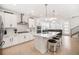 Bright, open kitchen featuring white cabinets, stainless steel appliances, and a large island with seating at 7889 Yampa River Ave, Littleton, CO 80125