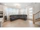 Comfortable living area featuring a plush sectional sofa, large windows, and elegant chandelier lighting at 7889 Yampa River Ave, Littleton, CO 80125