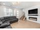 Bright living room featuring a modern fireplace, large TV, and comfortable seating area with natural light at 7889 Yampa River Ave, Littleton, CO 80125