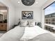 Bright bedroom featuring a large window, contemporary lighting fixture, and stylish decor at 1898 S Bannock St # 404, Denver, CO 80223