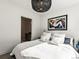 Bright bedroom features large bed, modern light fixture and colorful artwork at 1898 S Bannock St # 404, Denver, CO 80223