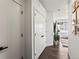 Clean, modern hallway with hardwood floors, white doors, and artwork leading to the living space at 1898 S Bannock St # 404, Denver, CO 80223