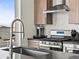 Modern kitchen featuring stainless steel appliances, custom cabinetry, and a view of the outside at 1898 S Bannock St # 404, Denver, CO 80223
