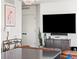 This modern living room features a large flatscreen, stylish bar cart, and contemporary decor at 1898 S Bannock St # 404, Denver, CO 80223