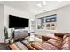 Cozy living room featuring a large TV, modern furniture, and a view of the building next door at 1898 S Bannock St # 404, Denver, CO 80223
