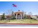 View of the community clubhouse featuring an American flag and well-maintained landscaping at 4605 Copeland Loop # 103, Highlands Ranch, CO 80126