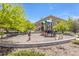 Community playground with swings and slide, surrounded by trees and grass at 4605 Copeland Loop # 103, Highlands Ranch, CO 80126