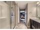 Bathroom featuring a glass-enclosed shower, modern vanity, and a glimpse into the main bedroom at 14315 Big Stone Dr, Parker, CO 80134