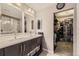 Bathroom with double sinks, modern fixtures, and a large walk-in closet with ample shoe storage at 14315 Big Stone Dr, Parker, CO 80134