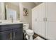 Stylish powder bathroom with a modern vanity, toilet, and white storage cabinets at 14315 Big Stone Dr, Parker, CO 80134