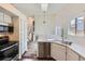 Modern kitchen with stainless steel appliances, white cabinets, quartz countertops, and stylish plank flooring at 9526 Pinebrook St, Highlands Ranch, CO 80130