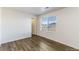 A bedroom with light colored walls, wood-look flooring, and a large window with blinds at 2231 Crosswind St, Fort Lupton, CO 80621