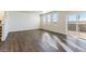 Open-concept living room with wood-look floors, natural light and sliding glass doors at 2231 Crosswind St, Fort Lupton, CO 80621