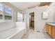 Bright bathroom with soaking tub, glass enclosed shower, and walk-in closet at 11223 Jansen St, Parker, CO 80134