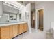 Bright bathroom with double sinks, tile flooring, and a walk in closet at 11223 Jansen St, Parker, CO 80134